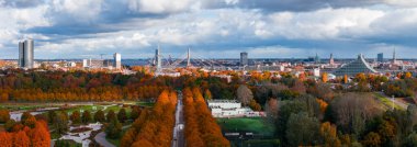 Öğleden sonra Letonya 'nın Riga kentinin hava manzarası şehre, Vansu Köprüsü' ne, Daugava Nehri 'ne ve Ulusal Kütüphane' ye giden portakal ağaçlarıyla dolu geniş bir parkı gösteriyor.