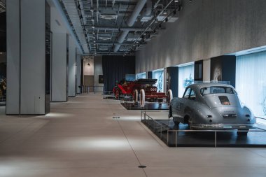 Minimalist galeri, Japonya 'daki bir Toyota müzesinde gümüş bir orta çağ coupe ve yükseltilmiş platformlarda kırmızı bir yarış arabası sunar..