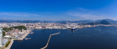 Hiroşima liman ve körfezinin havadan görünüşü kırmızı asma köprüsü, rıhtımlar, dalgakıranlar ve gemiler, açık gün ışığı, dağlar ötesinde, Hiroşima Bölgesi, Japonya.