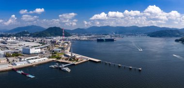 Hiroşima Körfezi 'nin rıhtımı, limanları ve gemileri olan havadan görüntüsü. Köprüler Miyajima ve Itsukushima Tapınağı 'na kadar uzanıyor. Parlak yaz ortası ışığı.