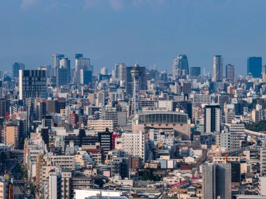 Japonya 'nın merkezi Osaka' nın havadan görünüşü, Tsutenkaku Kulesi ve Osaka Kalesi görünür. Demiryolu hatları ve dar sokaklar yumuşak sisli gün ışığında yoğun bloklar oluşturuyor..