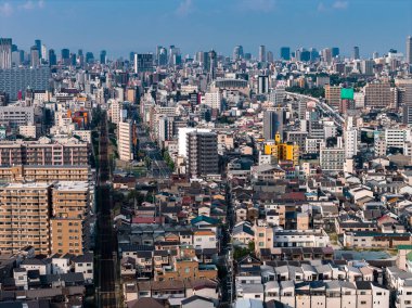 Japonya, Osaka 'nın hava manzarası, sıkışık caddeleri, yükseltilmiş demiryolu hatlarını, düşük katmanlı evleri ve temiz gün ışığında modern yüksek binaları gösteriyor.
