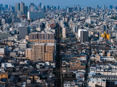 Kalkış blokları ve kalabalık evler Osaka, Japonya 'yı dolduruyor, demiryolu iskeletten geçiyor. Gün ışığı ve yüksek karşıtlık yüksek bir görünümdeki dokuyu ve yoğunluğu tanımlar.