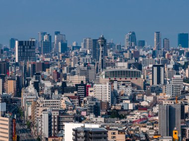 Yoğun Osaka silueti Naniwa ve Shinsekai 'deki Tsutenkaku Kulesi ve Osaka Bölgesi Spor Salonu' nu gösteriyor. Demiryolu hatları ve yollar gün ışığında, havadan görülür..