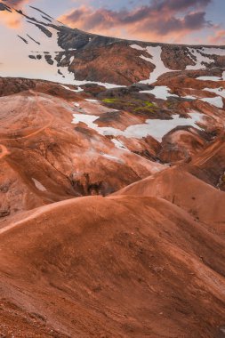 Kerlingarfjoll, İzlanda 'da yosun yosunlu tepeler ve dere yatakları. Sıcak altın ışık günbatımında turuncu tonları ve sıvı formları vurgular.