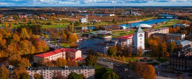 Letonya 'nın Jelgava kentinin hava sonbahar manzarası St. Trinity Kilisesi Kulesi, Lielupe Nehri, köprüler, ada parkı ve Zemgale Olimpiyat Merkezi' nin öğleden sonra güneşini gösteriyor..