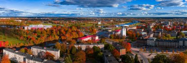 Öğleden sonra Letonya, Jelgava 'nın hava görüntüsü Jelgava Sarayı, Kutsal Üçleme Kulesi, köprüler, gezinti güverteleri, kanallar ve Lielupe Nehri kenarındaki sonbahar renklerine sahip parkları gösteriyor..