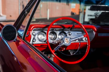 Monterey, California 'da klasik bir Amerikan iç mekanının yakın görüntüsü, kırmızı tekerlek, krom çizgi, yuvarlak göstergeler, sıcak kıyı ışığı, orta yüzyıl tasarımı..