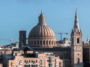 Valletta, Malta şehir manzarası bazilika kubbesi ve profesyonel katedralin kireçtaşı binaların, terasların ve vinçlerin üzerinde yükseltilmiş bir bakış açısından açık bir şekilde yükseldiğini gösteriyor..