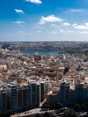 Sliema 'da yüksek açılı manzara, Malta modern blokları, Marsamxett Harbour, ve Valletta bazilika kubbesi ve St. Pauls Pro Katedral kulesini gün ortasında göstermektedir..