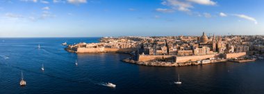 Hava manzarasına göre Valletta, Malta, Grand Harbour, bazilika kubbesi ve Kireçtaşı kalelerinin ve Barok bloklarının üstündeki kuleyi geçen yelkenliler var..