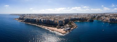 Sliema, Malta hava sahaları deniz kenarındaki daireleri, kayalık kıyıları, Marsamxett Limanı 'nı sağ, açık deniz solunu, küçük tekneleri, güneşli terasları, açık günü, yüksek kontrastı gösteriyor