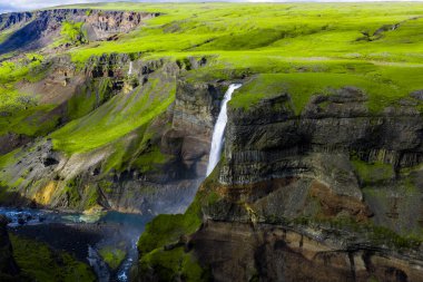 Hava görüntüsü, İzlanda 'nın güneyindeki Haifoss' un Fossa i Thjorsardal 'a düştüğünü gösteriyor. Katı bazalt kayalıkları, yosun platoları, yumuşak gün ışığı, sis ve yaz tonlarıyla..