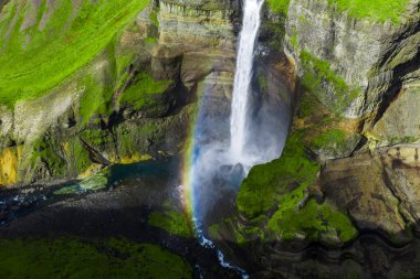Havadan bakıldığında Haifoss 'un İzlanda, Thjorsardalur' da yosunlu bir vadiye düştüğünü görüyoruz. Parlak gün ışığı zümrüt yamaçları, karanlık bazalt kayalıkları ve gökkuşaklı bir turkuaz havuzu gösterir..
