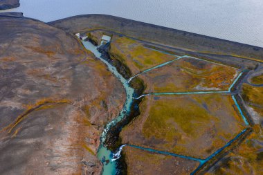 Havadan bakıldığında İzlanda 'da Sigoldugljufur yakınlarında volkanik bir platoda dönen bir turkuaz nehir görülüyor. Mavi kanallar bazalt ve yosun içeren su setleri ve alanlar çiziyor.