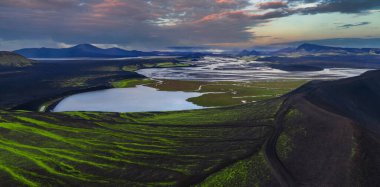 Hava panorama, Landmannalaugar yakınlarındaki İzlanda dağlarını gösteriyor. Kara kül ovaları, örülmüş nehirler, yeşil yosunlu bir göl, ryolite dağları ve düşük ışıktaki lav tarlaları..