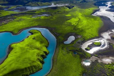 Hava görüntüsü, Landmannalaugar ve Fjallabak, İzlanda 'daki volkanik arazide yaz güneşiyle birlikte serpentin buzul nehirleri, kobalt gölleri ve yosunları gösteriyor..