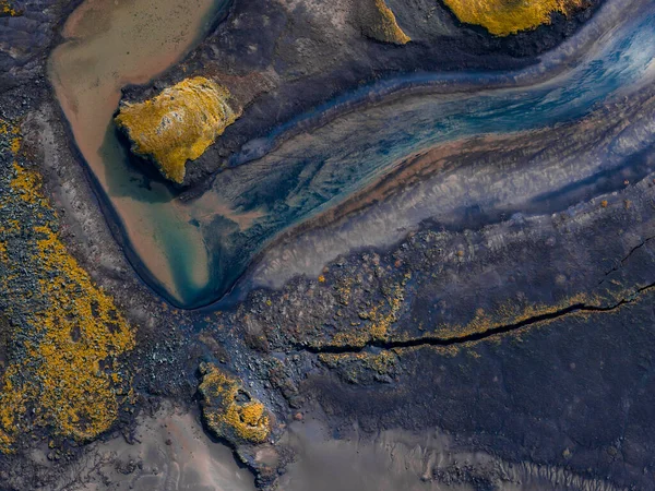 Örülmüş deniz mavisi ve sütlü nehirler Güney İzlanda 'da, Landmannalaugar yakınlarında, koyu kumlar ve yosun adacıkları arasında süzülür..