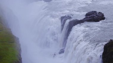 Yüksek İHA görüntüsü Gullfoss, güneybatı İzlanda 'da iki kademeli şelale gösteriyor. Sis ve köpük, kayalık bir adanın etrafındaki vadiyi doldurur..