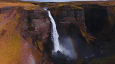 Hava aracı çekimleri Haifoss 'un İzlanda' da bazalt kanyonuna düştüğünü gösteriyor. Sis içinde bir gökkuşağı oluşur, nehir ince bir geçitte yol alır, elektrik hatları ufku gösterir, serin ışık yayılır..