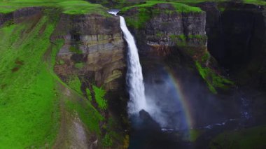 Hava aracı görüntüsü Haifoss 'un Thjorsardalur, İzlanda' da bir bazalt kanyona düştüğünü gösteriyor. Granni sağda ve gökkuşağı sisli, yaz ışığı, süpürme hareketi..