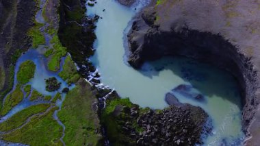 Yüksek açılı hava manzarası Sigoldugljufur, İzlanda 'daki sütlü turkuaz buzul suyunu örülmüş kanallar, yosun adaları, siyah lav ve küçük kanyon şelaleleri ile gösteriyor..