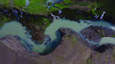 Sigoldugljufur, İzlanda 'nın havadan aşağı görüntüsü. Sütlü bir turkuaz ırmak S eğrisinde kıvrılır, dar şelaleler yosunlu kayalıklarda ve akan akıntılarla.