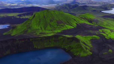 İzlanda Dağları 'ndaki canlı bir mavi krater gölü. Lav akıntılarındaki yosunlar, siyah kül, örülmüş nehirler ve yumuşak yaz ışığı altında ortaya çıkan kalderalar..