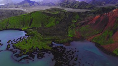 İzlanda 'daki hava manzarası Landmannalaugar lavı, yeşil yosun, rhyolit çıkıntıları, krater gölleri ve yazın hafif bulutlu ışık altında örülmüş nehir ovalarını gösteriyor..