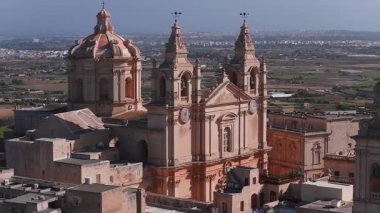 Mdina, Malta havadan bakıldığında, Barok katedrali ve kuleleri, kompakt şehir duvarlarını, kireçtaşı çatılarını ve sıcak gün ışığında uzak sahilleri gösteriyor..