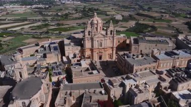 Mdina, Malta 'daki St. Pauls Katedrali' nin havacılık merkezleri kireçtaşı çatıları, avluları, güneş panelleri, tarlaları ve parlak gölgeli yollarla aydınlık gün ışığında.