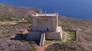 Comino, Malta 'daki Saint Mary Kulesi' nin havadan görüntüsü. Temel, uzun merdivenler, iskeleler ve mavi ambalajlar parlak deniz ve kayaların yenilendiğini gösteriyor..