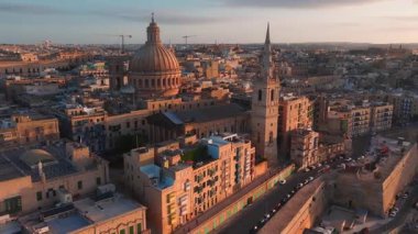 Akşam karanlığında Valletta 'nın eski kasabasının havadan görünüşü, Mount Carmel kubbesi, St Pauls kulesi, kireçtaşı kale duvarları, dar sokaklar, Malta balkonları ve Grand Harbour.