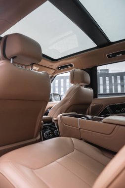 Kontrastlı deri kaplama, panoramik cam çatı, arka klima kontrolleri, geniş merkez konsol, ön koltuklar, kapalı bir lüks araba atölyesinde