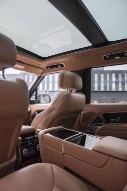 Arka koltuklardan öne doğru bakan, panoramik çatısı, arka iklim kontrolleri ve parlak merkez konsolu olan bir Range Rover otobiyografisi..