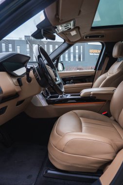 Yakın iç görünüş, HURM 'deki Range Rover otobiyografisinde bronz deri koltuklar, ahşap süsleme, parlak konsol ve panoramik sunroof gösteriyor..