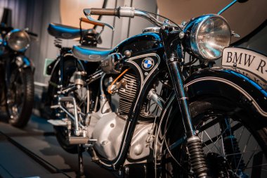 20. yüzyılın ortalarında BMW motorsiklet, sıcak müze ışıklarının altında, mavi beyaz yuvarlak, BMW R plakalı, siyah boyalı ve sığ alan derinliğinde..