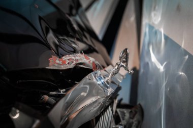 Yakından bakınca, bir otomobil müzesinde, kanatlı bir kaput süsü, hasarlı siyah kaput, soyulmuş kırmızı ve beyaz boya ve parıldayan ızgara ile klasik lüks bir araba görülüyor..