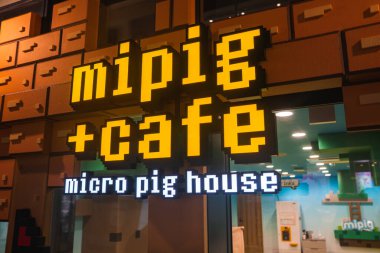 Tokyo 'daki bir mağaza vitrininde kalın bir pixelated mipig cafe tabelası var. Camlar, deniz mavisi duvarlar ve eğlenceli dekorlar sayesinde küçük domuz temalı bir kafeye davet edildim..