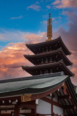 Asakusa, Tokyo 'daki Senso ji' deki Beş Katlı Pagoda, mavi ve pembe bir akşama karşı, uzun, kırmızı kirişler ve kıvrımlı saçaklar üzerinde duruyor..