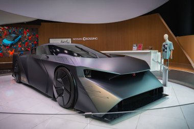 Ginza, Tokyo 'daki Nissan Kavşağı' nda siyah renkli bir konsept araba, jilet gibi kenarları, kaplamalı tekerlekleri, ince farları, perakende tezgahları ve yakındaki duvar resimleriyle birlikte duruyor..