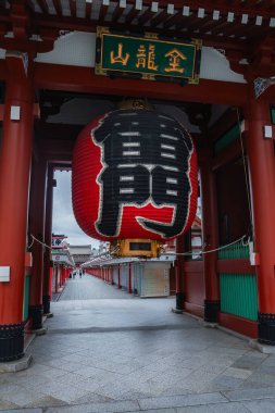Tokyo, Asakusa 'da Kaminarimon' da kırmızı bir fener asılı. Nakamise dori 'ye bakın. Kapalı tezgahlar, kırmızı sütunlar, yeşil paneller ve altın aksanlar gösteriyor..