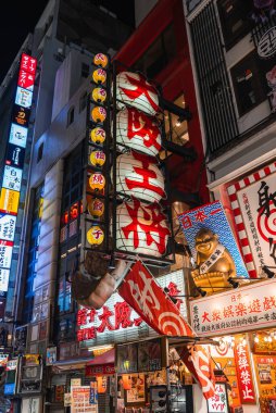 Kalabalık gece Osaka Dotonbori 'de yürüyor, neon ışıkları parlıyor, fenerli Osaka Ohsho tabelası dimdik ayakta duruyor, altın rakunlar ve dev gyoza restoranlara restoran çekiyor..