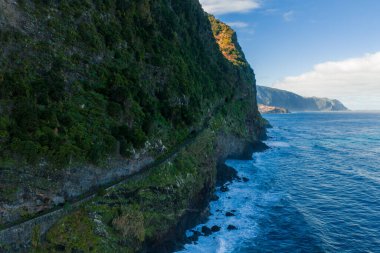 Öğleden sonra geç saatlerde Madeira, Portekiz 'deki bazalt kayalıkları ısıtır. Dalgalar Atlantik' in yukarısındaki dar bir yolun altında, izolasyon ve vahşi sahil maceralarını taşır..
