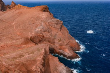 Ponta de Sao Lourenco, Madeira, Portekiz 'de engebeli volkanik burunlar, aşınmış kayalıklar, köpüklü sörfler ve parlak gün ışığı altında solgun yürüyüş yolları geniş bir görüş altında..