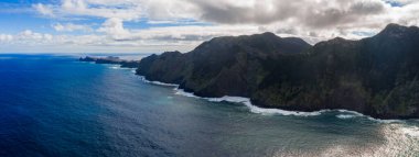 Gündüz vakti Ponta de Sao Lourenco ve Porto Moniz yakınlarındaki tırtıklı burunlar ile Madeira 'daki engebeli bazalt kayalıkları ve beyaz sörf manzarası..