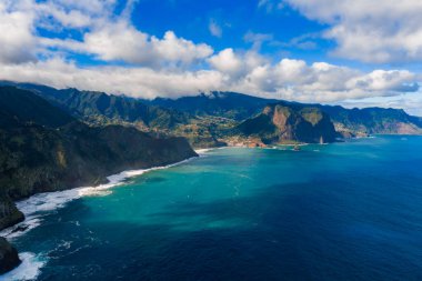 Hava görüntüsü Madeira 'nın kuzey kıyısı kayalıklarının Atlantik' le buluştuğunu, Ponta de Sao Lourenco yakınlarındaki yerleşim yerlerine ve teraslara eğildiğini ve Pico do Arieiro 'ya doğru yükseldiğini gösteriyor..
