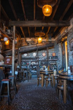 Loş kehribar kolye ışıkları varil masaları, kaldırımlı zemin, ve raflar şişeler Funchal, Madeira, Portekiz 'de tarihi bir şarap barı.