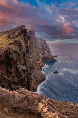 Ponta de Sao Lourenco, Madeira, Portekiz 'de engebeli volkanik kayalıklar yükseliyor. Tırtıklı burunlar ve izole edilmiş deniz yığınları gün batımında dalgaların yere çakılmasıyla.