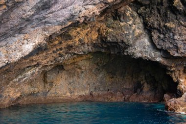 Madeira 'nın Ponta de Sao Lourenco kenti yakınlarındaki derin turkuaz suyla pürüzlü mağara duvarları oluşturulur. Yumuşak gün ışığı dokuları, gelgit izlerini ve durgunluğu ortaya çıkarır..